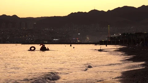 Sea with mountain view, sunset, orange sky, family vacation 스톡 동영상 119321775