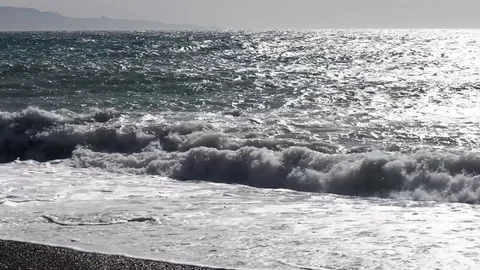 The sea moved by the strong wind crashes with strong waves on the beach Stock Footage 84024740