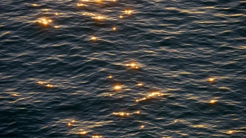 Sea (ocean) is waving while the setting sun is reflecting in its waters. Dots of Video stock 107086677