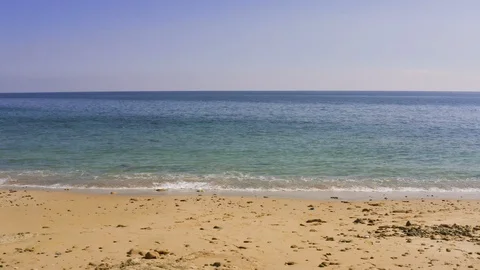 Sea or ocean, small waves, sandy beach, blue azure water, low tide at morning or Stock-Footage 126934271