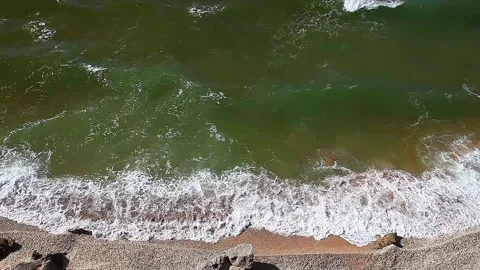 Sea or ocean, surf on a sandy beach with rocks and greenish water Stock Footage 136535870