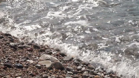 Sea pebbles and waves in sunlight Stock Footage 107199179