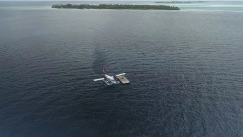 A sea plane is parked at a floating platform in the middle of an ocean lagoon Stock Footage 150661529
