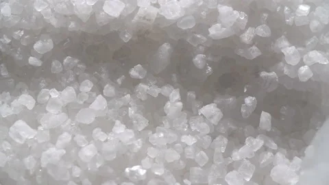 Sea salt is mixed with a white plastic spatula in a contrasting light Stock Footage 179535993