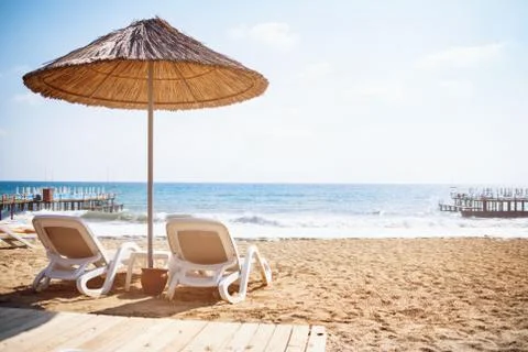 Sea sandy beach with the two deck chairs. Stock Photos