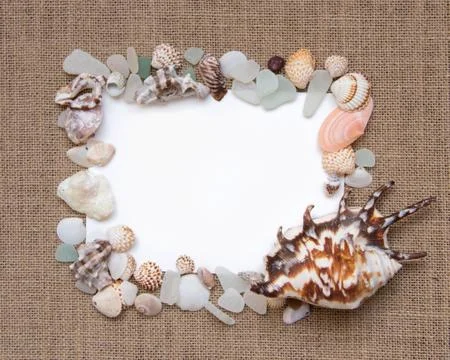 Sea shell border on burlap texture Stock Photos