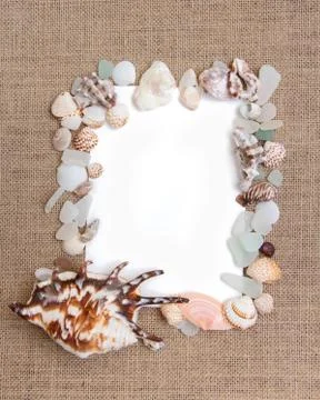 Sea shell border on burlap texture Stock Photos