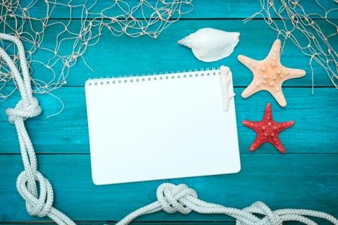 Sea shells, notepad and rope on old boards Stock Photos