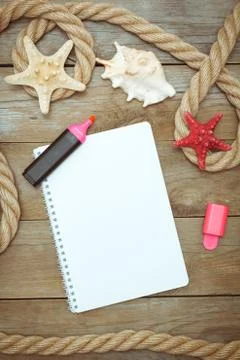 Sea shells, notepad and rope on old boards Stock Photos