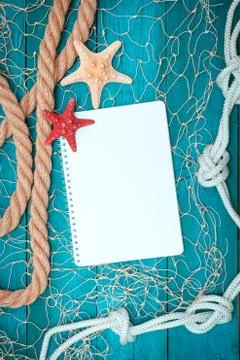 Sea shells, notepad and rope on old boards Stock Photos