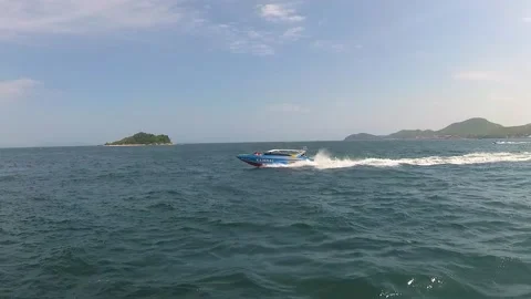 At sea, a ship with a camera overtaking a blue speedboat.  Stock Footage 130903833
