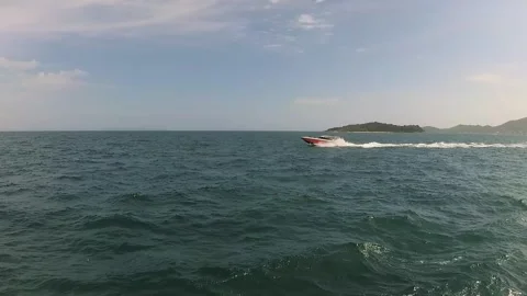 At sea, a ship with a camera overtaking a red and white speedboat Video stock 130903856