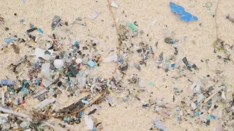 Sea shore pollution. Close up of microplastic particles and debris on sandy Stock-Footage 287350133