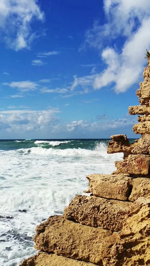 Sea splash against rocks in Caesarea coastline, dramatic coastal landscape, trav Stock Footage 334426228