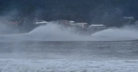 Sea spray form massive waves that are braking along coastal town   Stock Footage 64328925