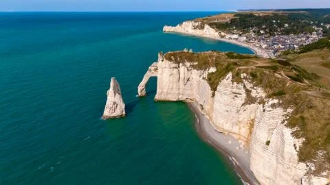Sea Stack And Natural Archway Rising From Calm Emerald Water Stock Photos