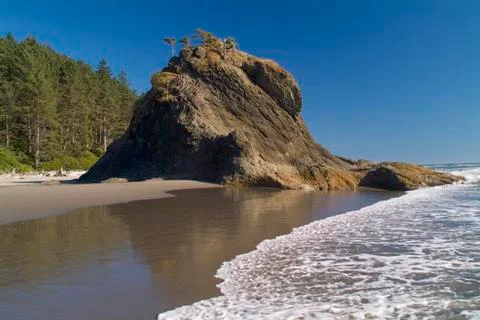 Sea stack on beach Stock Photos