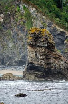 Sea Stack Rock Formation on Rugged Coastal Cliff with Vegetation and Ocean .. Stock Photos