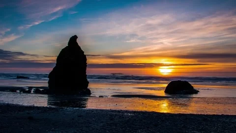 Sea stack rocks on coastal beach at sunset, wide shot 스톡 동영상 342396155