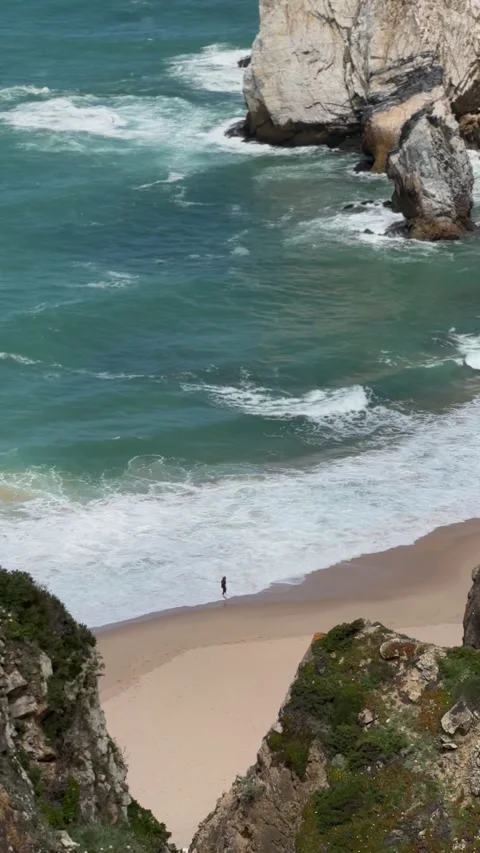 Sea stacks and waves on hidden sandy beach below cliffs, Portugal Stock Footage 346581923