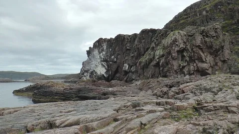 The sea, steep cliffs and stony shore. Colony of birds. Stock Footage 74104396
