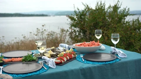 Sea style dining table outdoors with close up of glass of wine, caprese Stock Footage 114693835