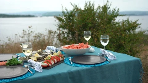 Sea style dining table outdoors with close up of glass of wine, caprese Stock Footage 114693961