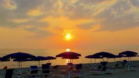 Sea Sunset Against the Background of Beach Umbrellas and Chairs. Fantastic View  Stock Footage 231142631