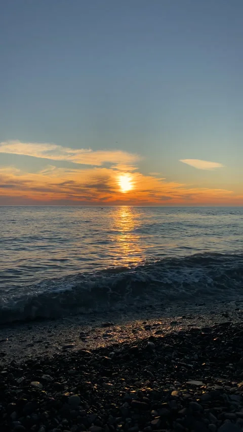 Sea on a sunset background and reflection of rays in the water. Vertical video. Stock Footage 294973875