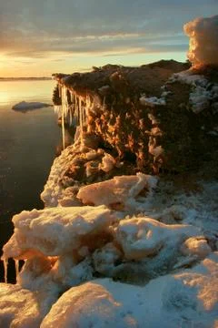 Sea on sunset with icicles Stock Photos