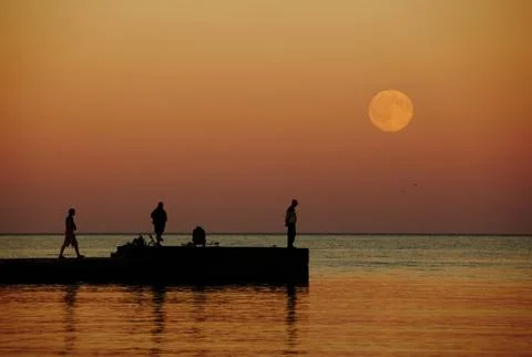 Sea sunset with large moon Stock Photos