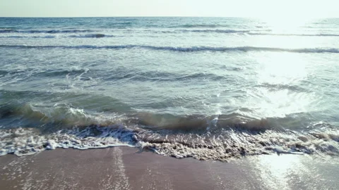 The sea at sunset, not large waves wash the sandy shore, sunlight on the water Stock Footage 304315792