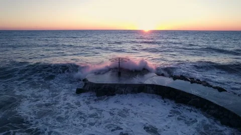 The sea at sunset. A wave breaks on the pier. Storm at sea. Stock Footage 231900633