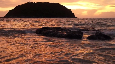 Sea surf on a sandy beach with rock at sunset. Stock Footage 120518320