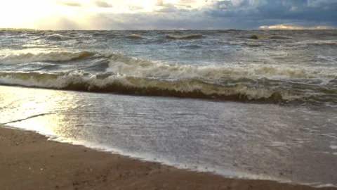 The sea surf. The waves of the bay roll onto the sandy shore in windy weather Stock Footage 262571281