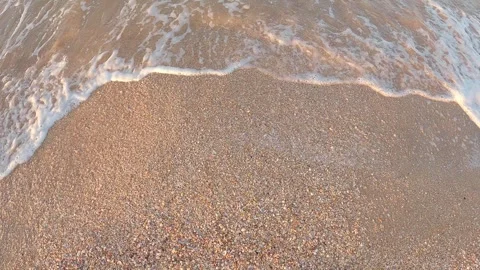 Sea surf with white foam on shell beach Stock-Footage 242356928