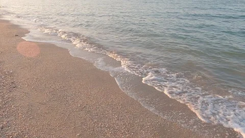 Sea surf with white foam on shell beach, diagonally at sunset 스톡 동영상 245518238