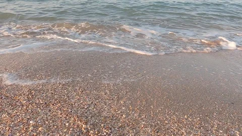 Sea surf with white foam on shell beach 库存影片 245518254