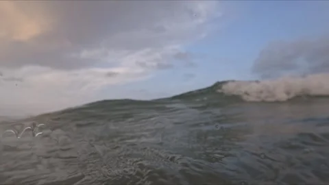 Sea surface and underwater waves filmed together at sunset showing bubbles .. Stock Footage 342586822