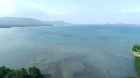 The sea surface is calm with sharp mountains around Stock Photos