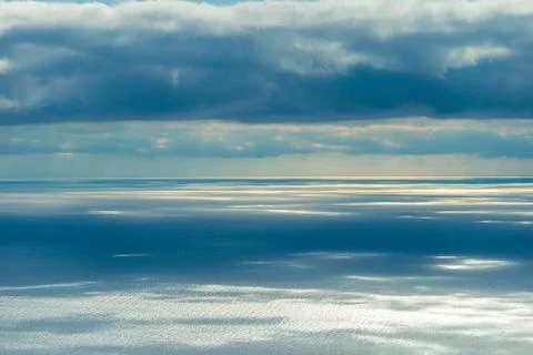 Sea surface in the rays of the sun breaking through the clouds Stock Photos
