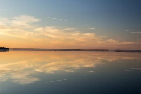 Sea surface with reflection of sky and clouds at sunset Foto stock