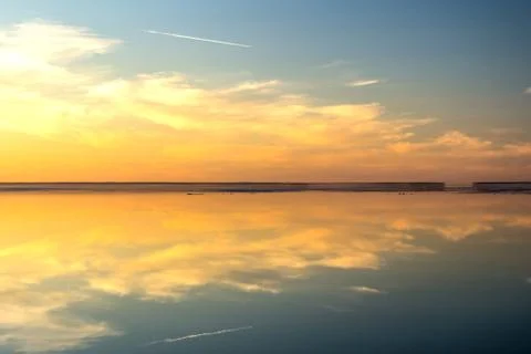 Sea surface with reflection of sky and clouds at sunset Foto stock