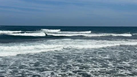 Sea surface shows rolling waves advancing steadily beneath open sky at the Stock-Footage 328300728