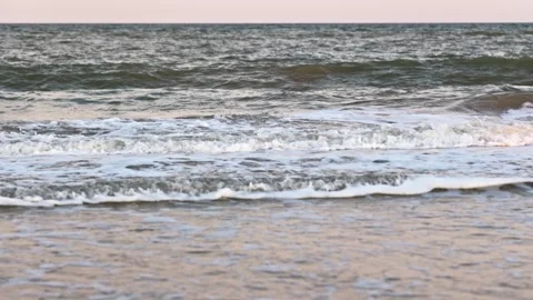 The sea under a cloudy sky with clouds on the beach with a lot of seashells Stock Footage 348025246