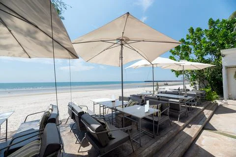 Sea view with dining table and umbrella on the beach Stock Photos