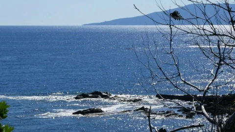 Sea view at midday with silver reflections and a far island Stock Footage 90834041