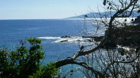 Sea view at midday with silver reflections and a far island Stock Footage 90834160