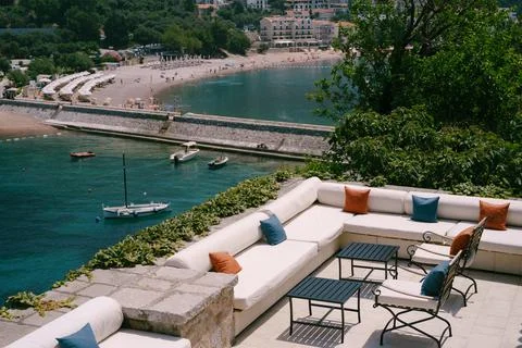 Sea view restaurant - cozy sofas with pillows and wrought iron chairs, near the 스톡 사진