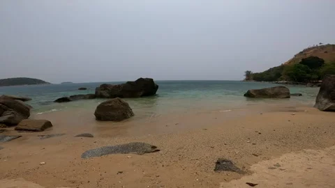 Sea view from the sandy beach on which there are large stones. Stock Footage 242167249